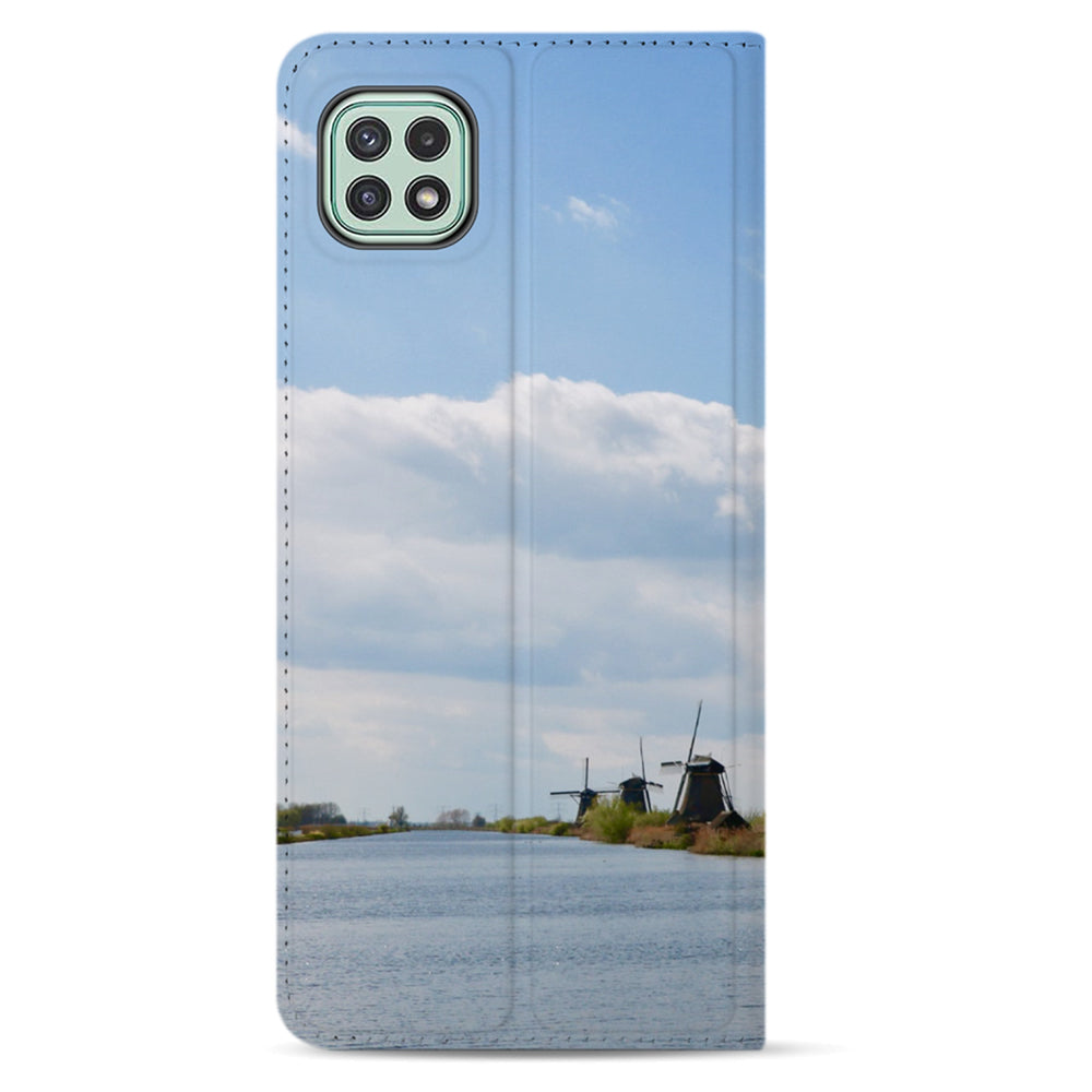 Achterkant van de Galaxy A22 5G standcase met vierkante camera-uitsparing; voorbeeld met wolkenlucht, water en windmolens