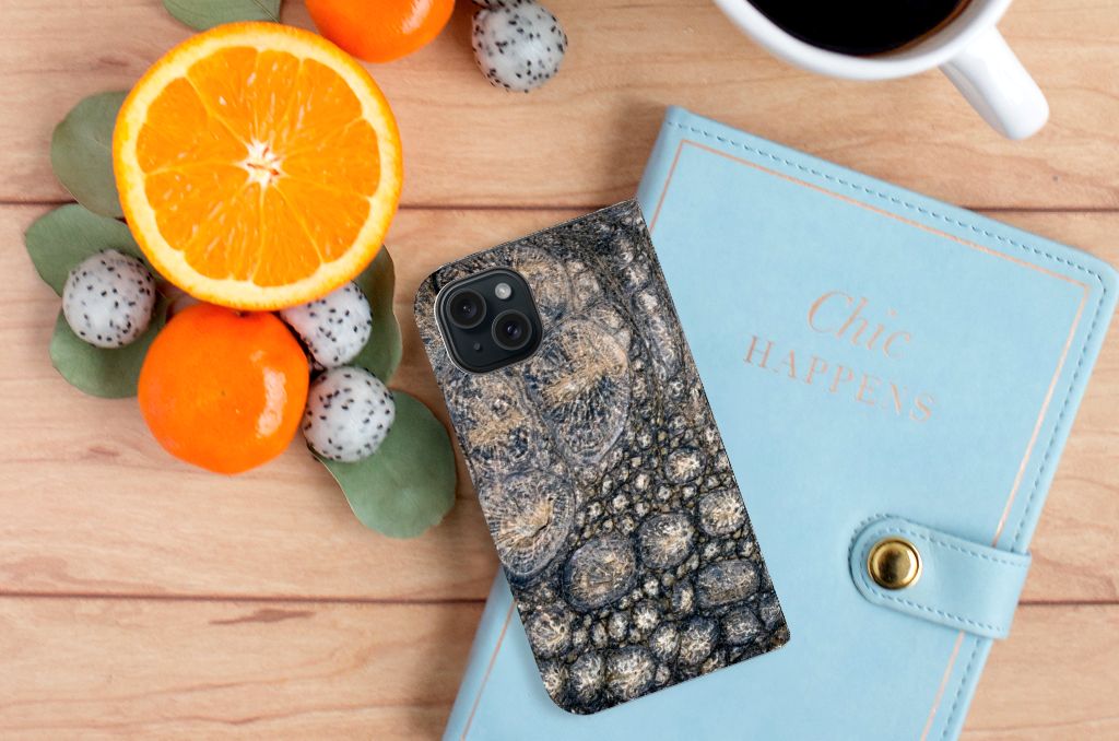 iPhone 15 Hoesje maken Krokodillenprint op een bureau met fruit en een notitieboekje.