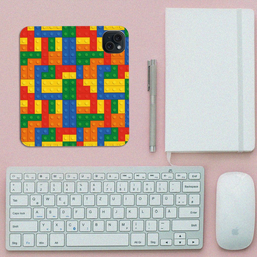 iPhone 15 Hoesje met Magneet Blokken met kleurrijke Lego-print op een bureau met toetsenbord en muis.