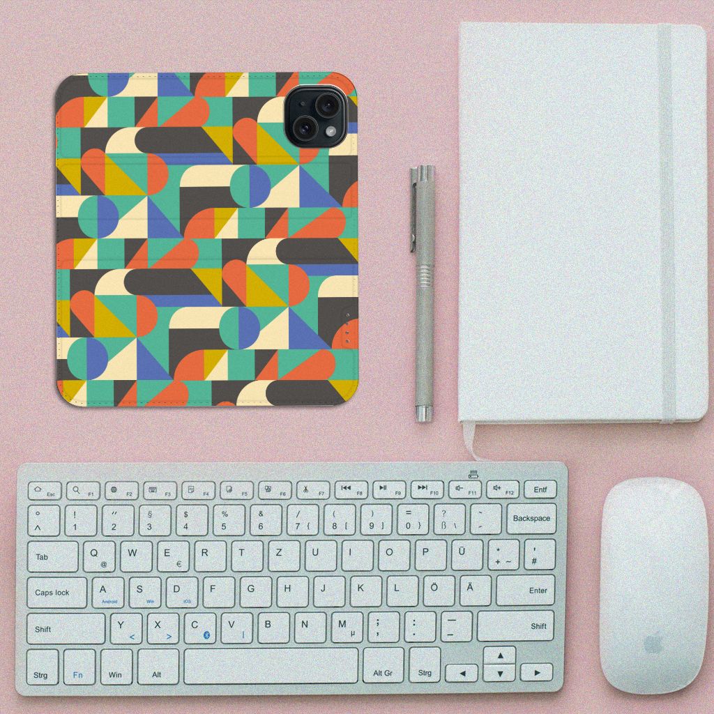 iPhone 15 Hoesje met Magneet Funky Retro met een kleurrijk geometrisch patroon op een bureau met toetsenbord en muis.