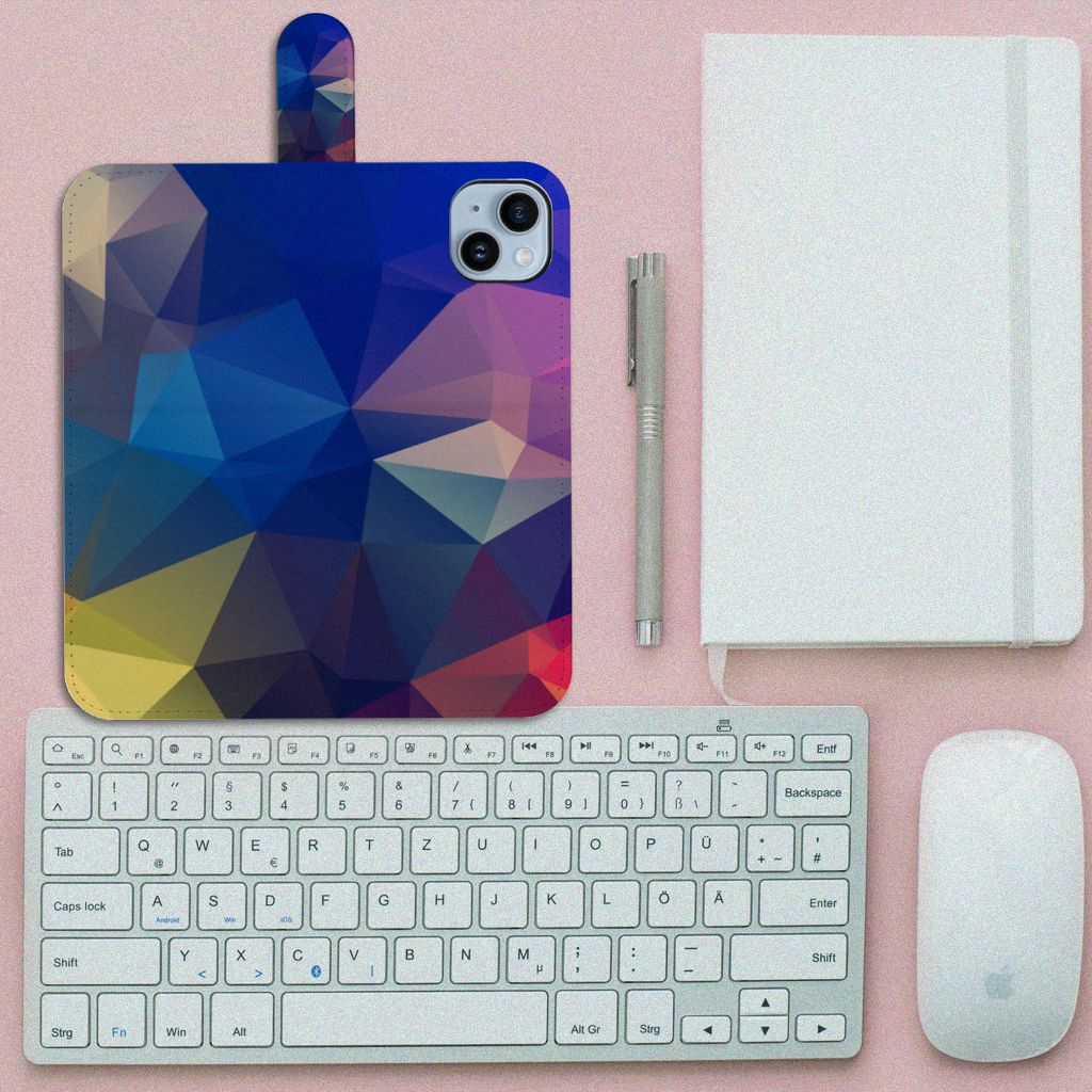 iPhone 15 Plus Book Case Polygon Dark op een bureau met toetsenbord en notitieboek, abstract design in warme kleuren.