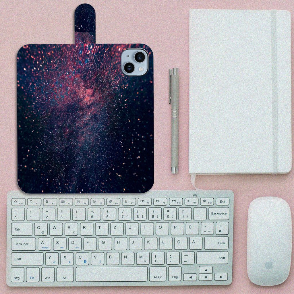 iPhone 15 Plus Book Case Stars met een kunstzinnige ruimteverloop op een bureau met toetsenbord.