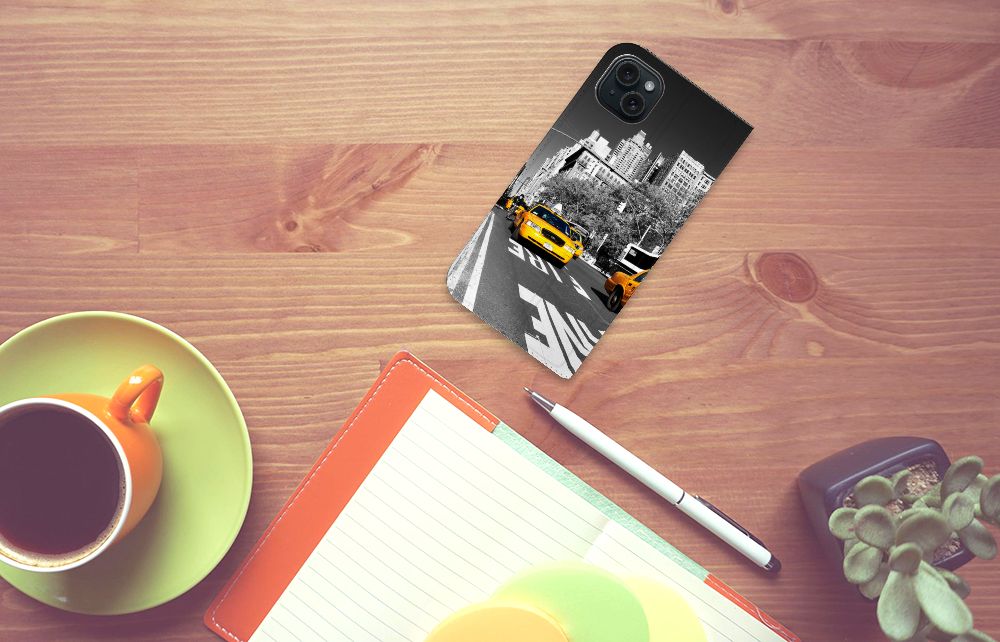 iPhone 15 Plus Book Cover New York Taxi op een bureau met een koffie en notitieboek.