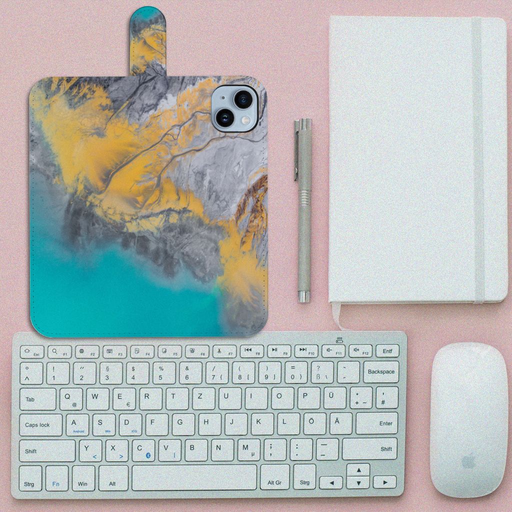 iPhone 15 Plus Bookcase Marble Blue Gold op een bureau met toetsenbord en muis, stijlvol marmerontwerp.
