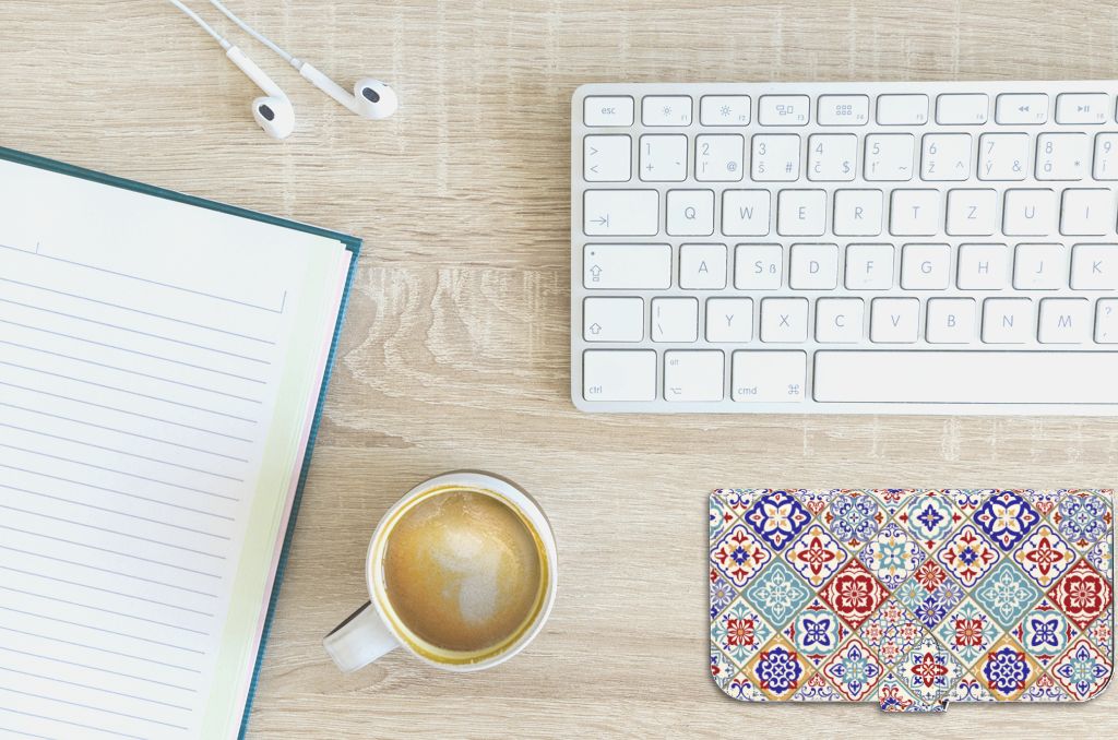 iPhone 15 Plus Bookcase Tiles Color met kleurrijk tegelpatroon op een bureau met koffie en notitieboek.