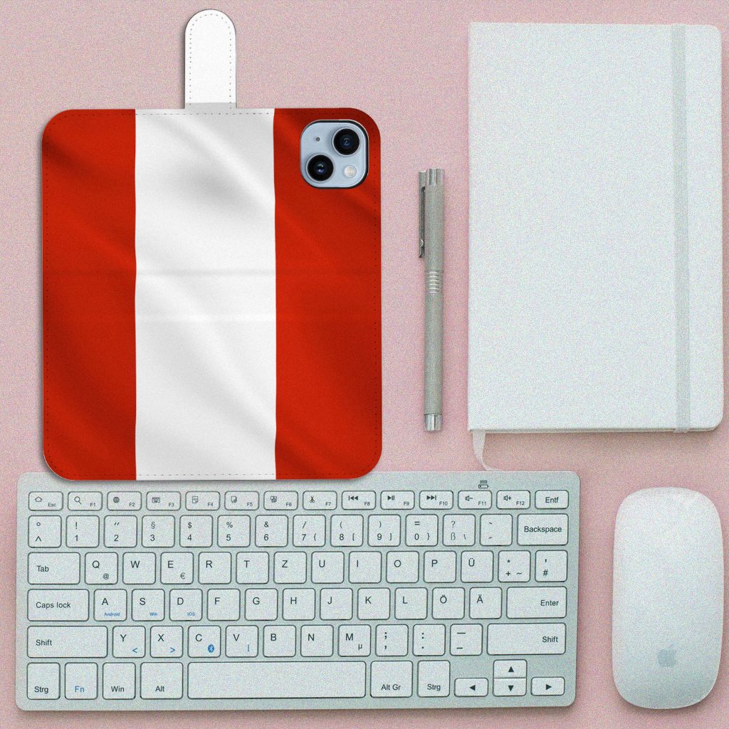 iPhone 15 Plus Bookstyle Case Oostenrijk met vlagontwerp op een bureau met toetsenbord en notitieboek.