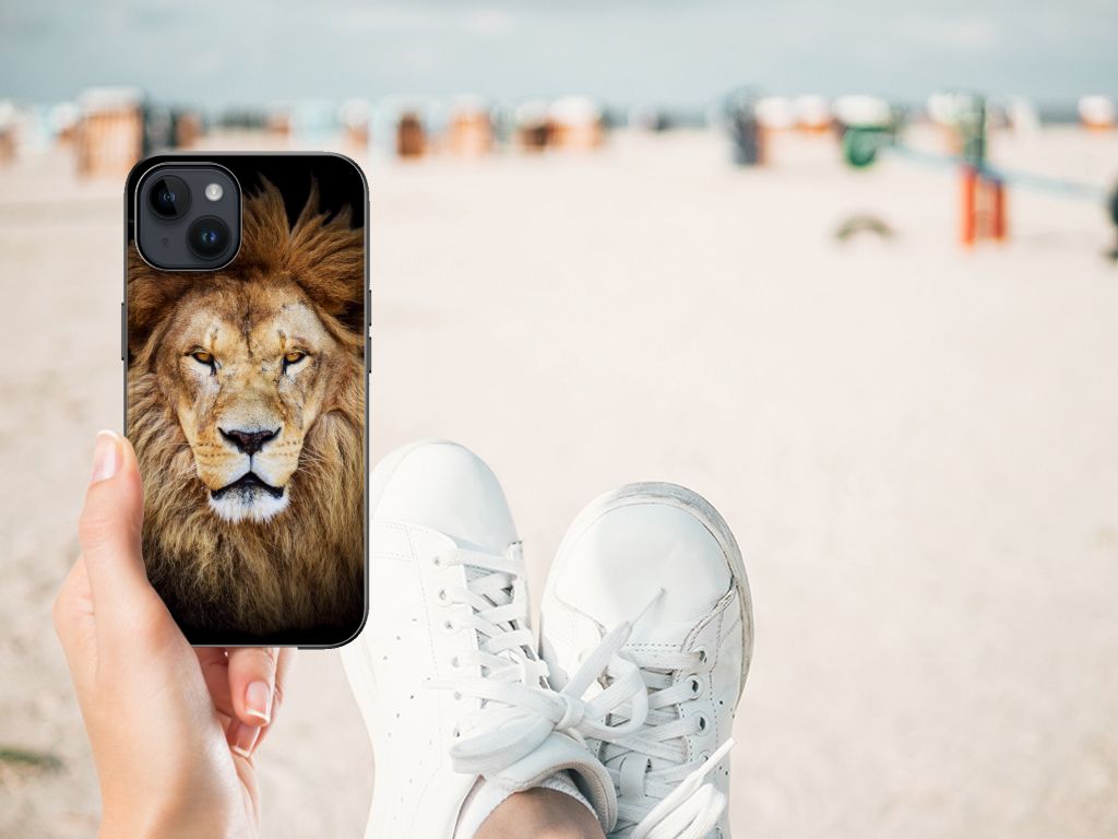Apple iPhone 15 Plus Dierenprint Telefoonhoesje Leeuw voorkant hand met sneakers strand