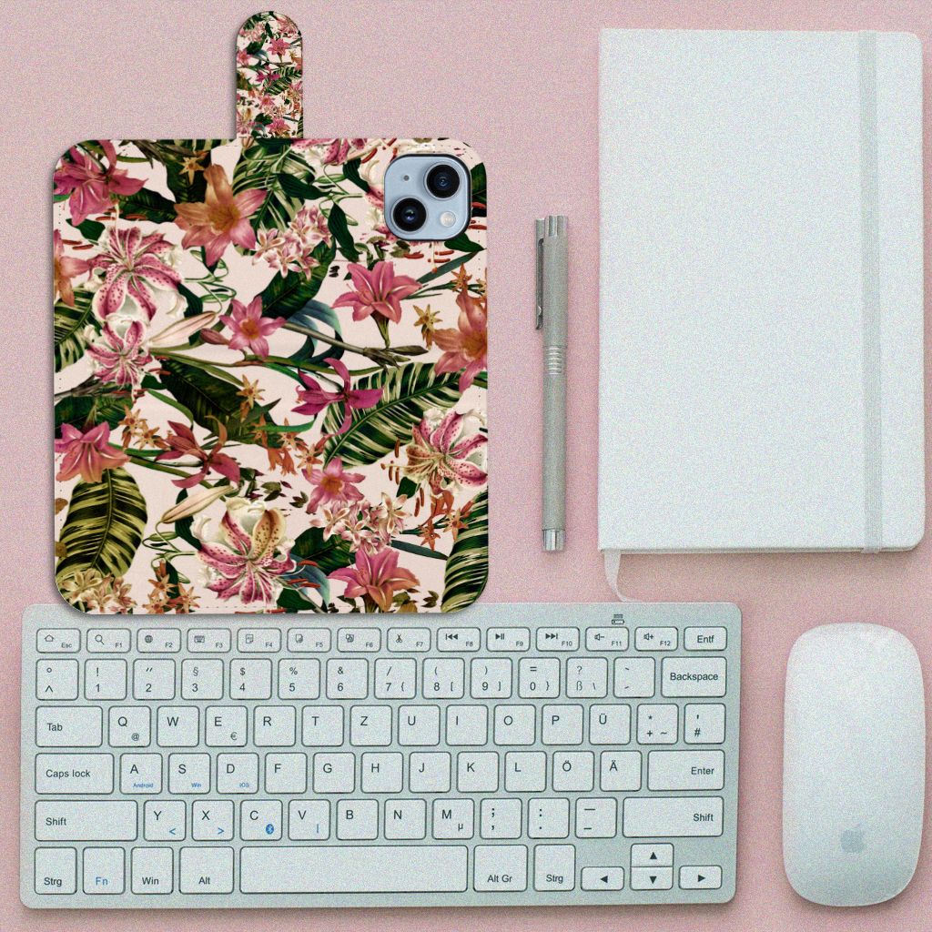 iPhone 15 Plus Hoesje Flowers met kleurrijke bloemen op een bureau met toetsenbord en notitieboek.