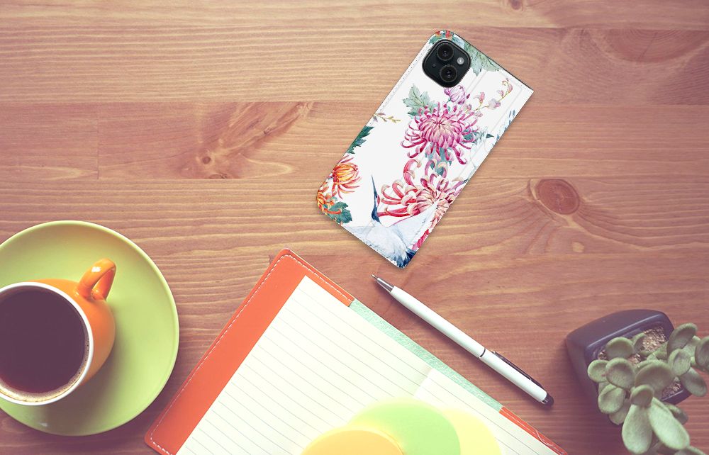 iPhone 15 Plus Hoesje maken Bird Flowers met een bloemdecor op een bureau met een mok koffie ☕ en notitieboek.