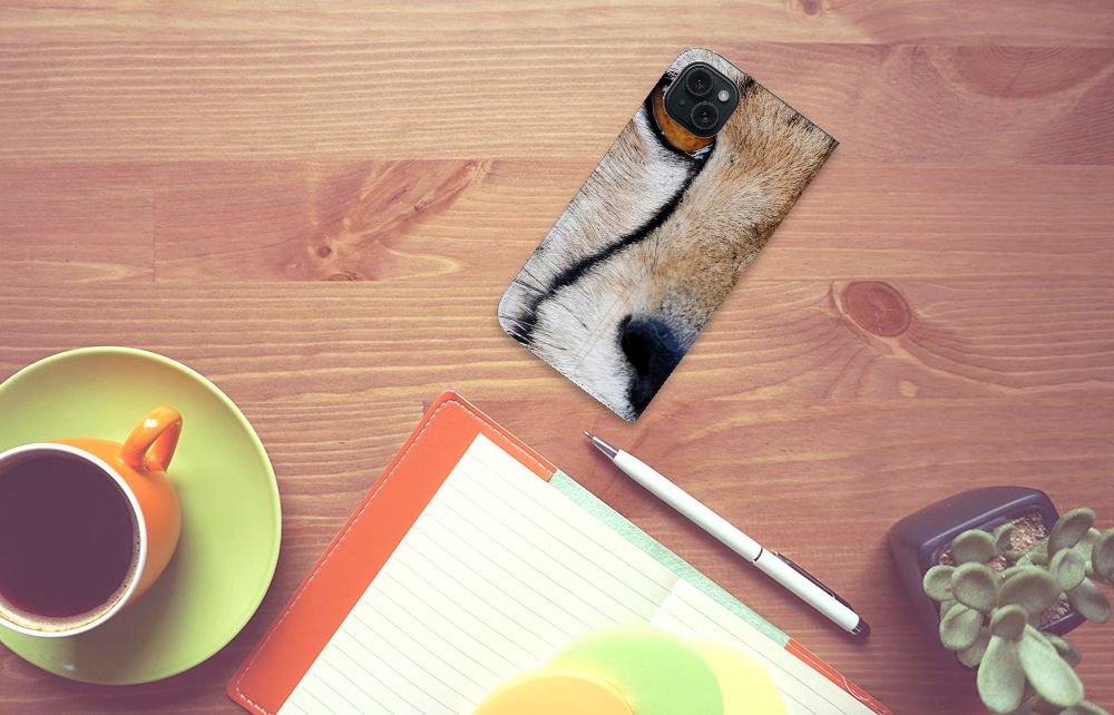 iPhone 15 Plus Hoesje maken Cheetah met close-up van jachtluipaard op bureau met koffiekop en notitieboek.