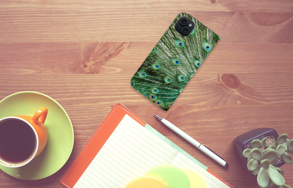 iPhone 15 Plus Hoesje maken Pauw met een kleurrijk pauwdesign op een houten tafel met een kopje koffie ☕.