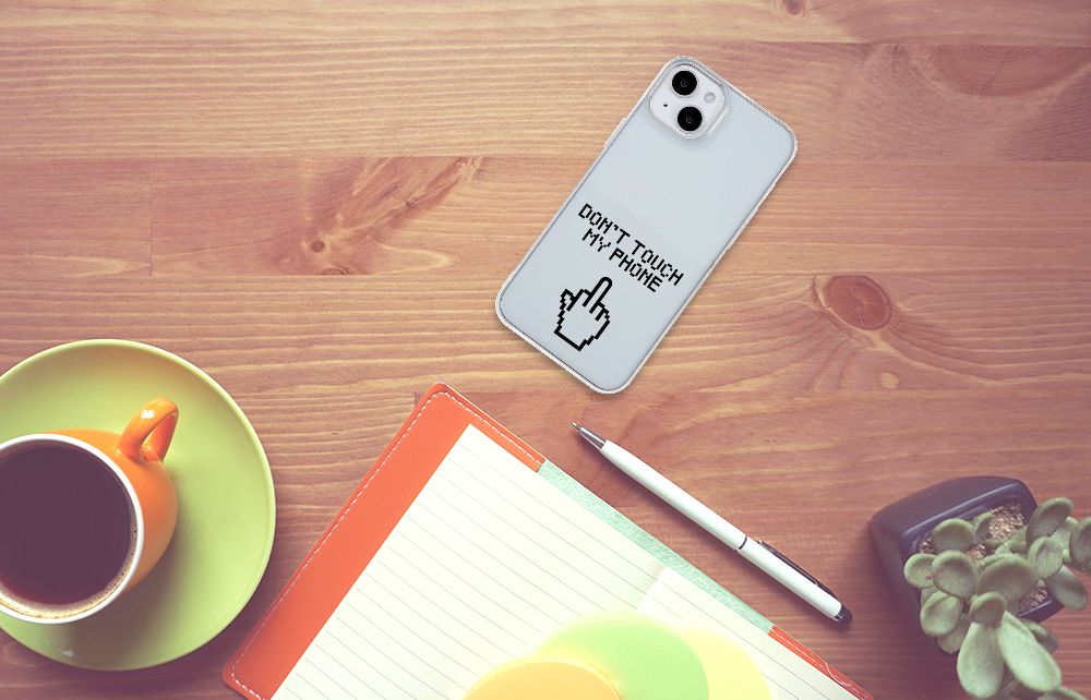 iPhone 15 Plus Silicone-hoesje Finger Don't Touch My Phone op een houten tafel met een kop koffie en notitieboek.