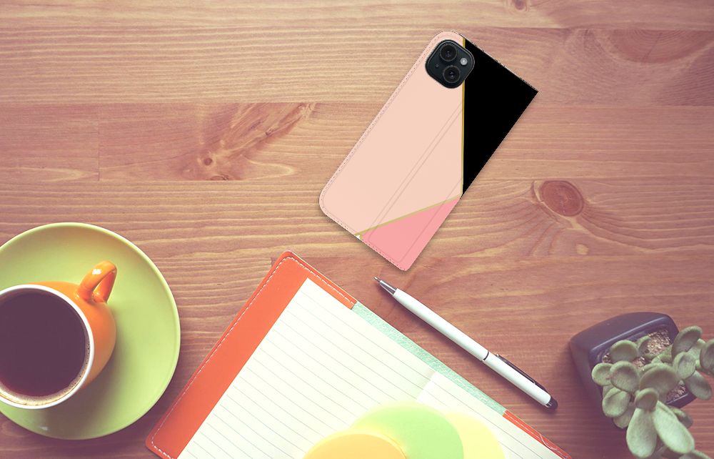 iPhone 15 Plus Stand Case Zwart Roze Vormen op een houten tafel met een kopje koffie en een notitieboekje.