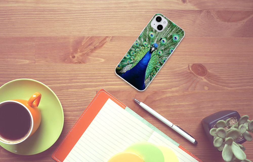 iPhone 15 Plus TPU Hoesje Pauw met een prachtig pauw design op een bureau met een kopje koffie ☕.
