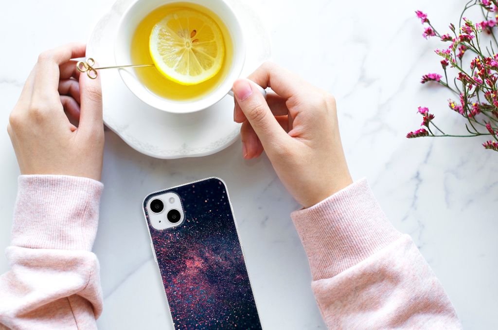 iPhone 15 Plus TPU Hoesje Stars met een sterrenhemel design, gehouden naast een kopje citroenthee.