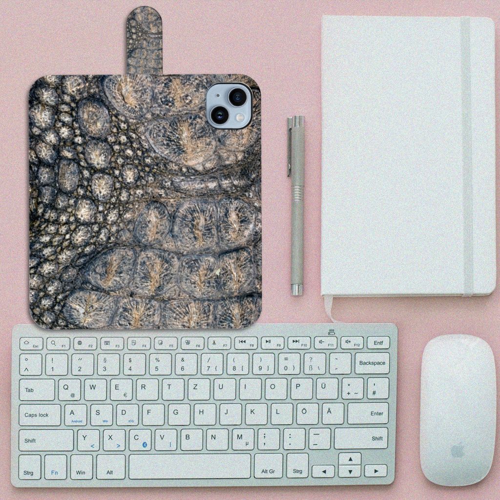 iPhone 15 Plus Telefoonhoesje met Pasjes Krokodillenprint op een bureau met een toetsenbord, muis en notitieboek.