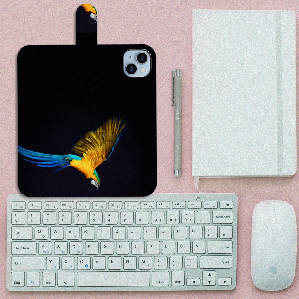 iPhone 15 Plus Telefoonhoesje met Pasjes Papegaai, met een kleurrijke papegaai print en laptoptoebehoren eromheen.