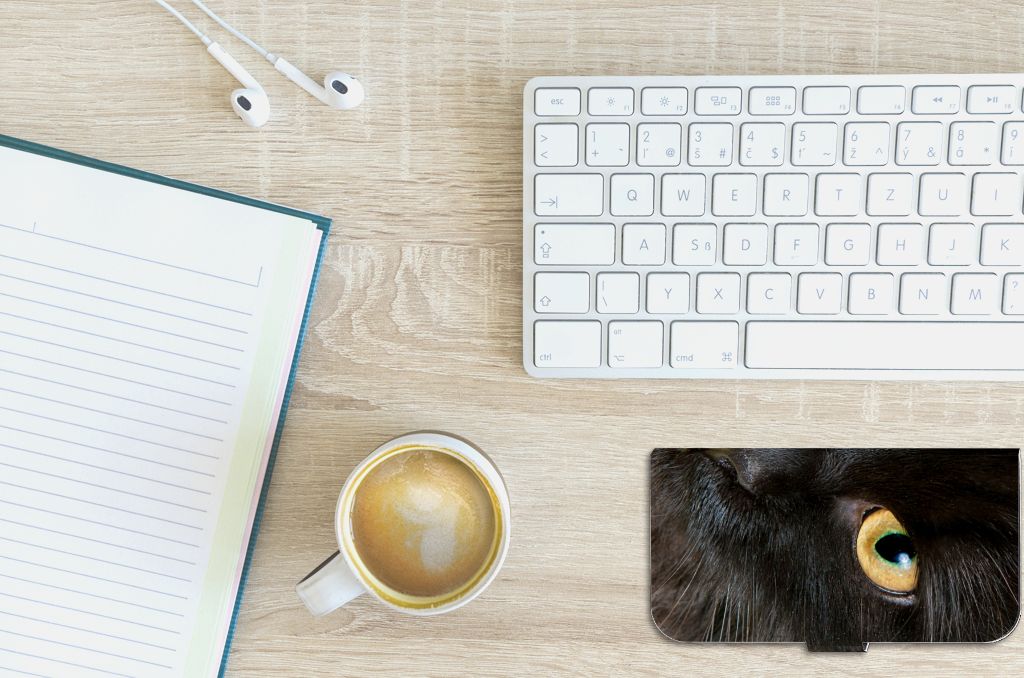 iPhone 15 Plus Telefoonhoesje met Pasjes Zwarte Kat op bureau met koffie en notitieblok.