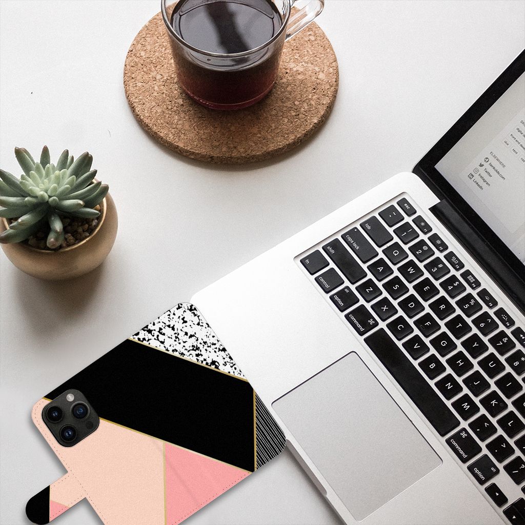 iPhone 15 Pro Book Case Zwart Roze Vormen op een bureau met laptop en planten - kleurrijk en beschermend.