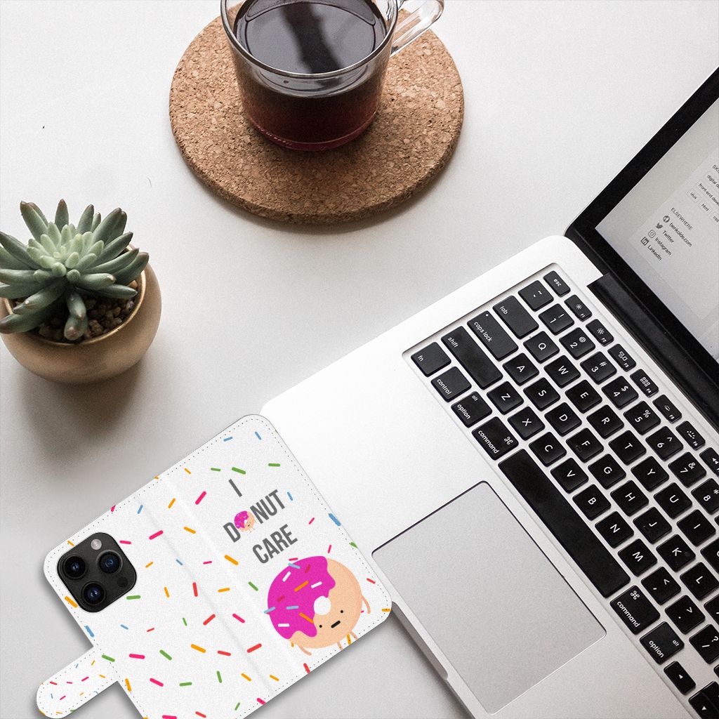 iPhone 15 Pro Book Cover Donut Roze met vrolijke donut en 'I donut care' woorden op bureau met laptop.