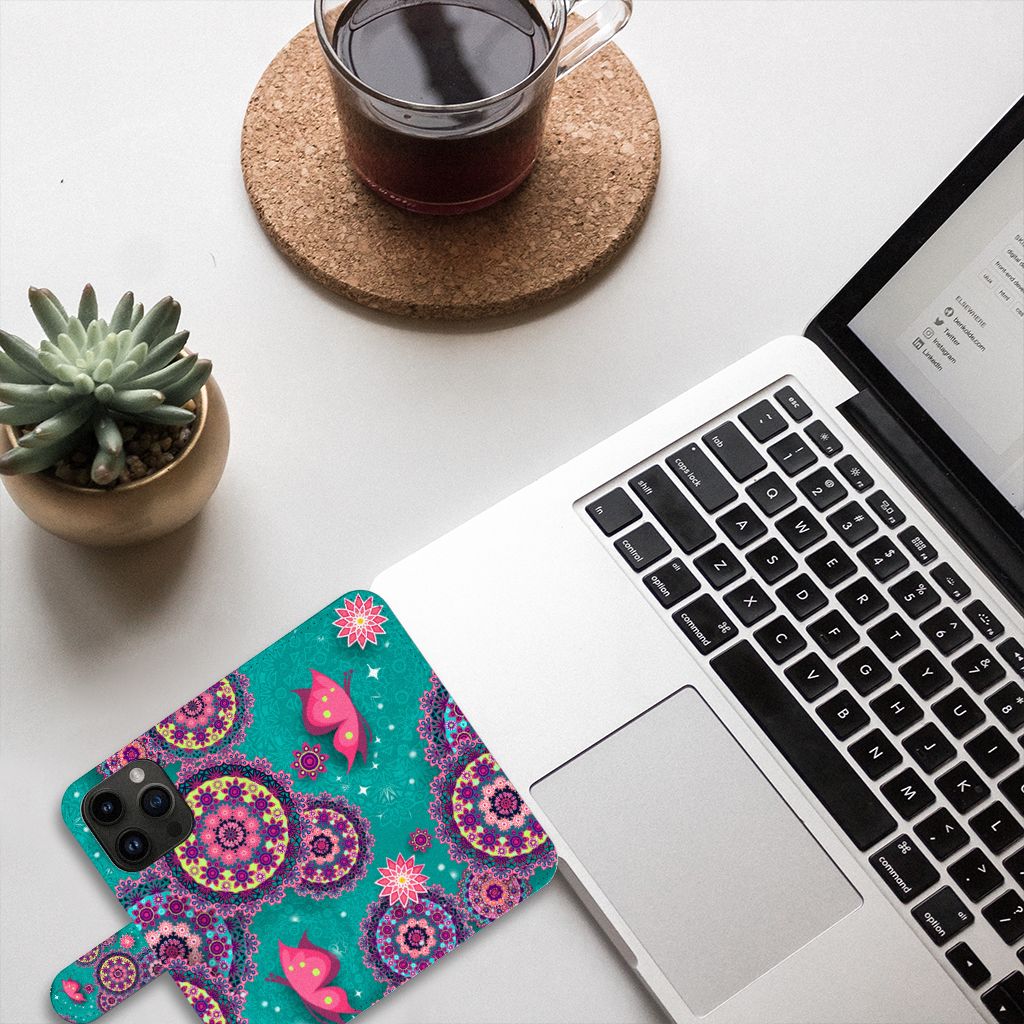 iPhone 15 Pro Hoesje Cirkels en Vlinders op tafel met laptop en koffie, kleurrijk hippie design.