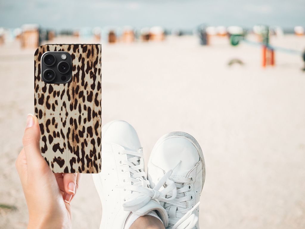 iPhone 15 Pro Hoesje maken Leopard met luipaardprint, vastgehouden in hand op een strand met sneakers.