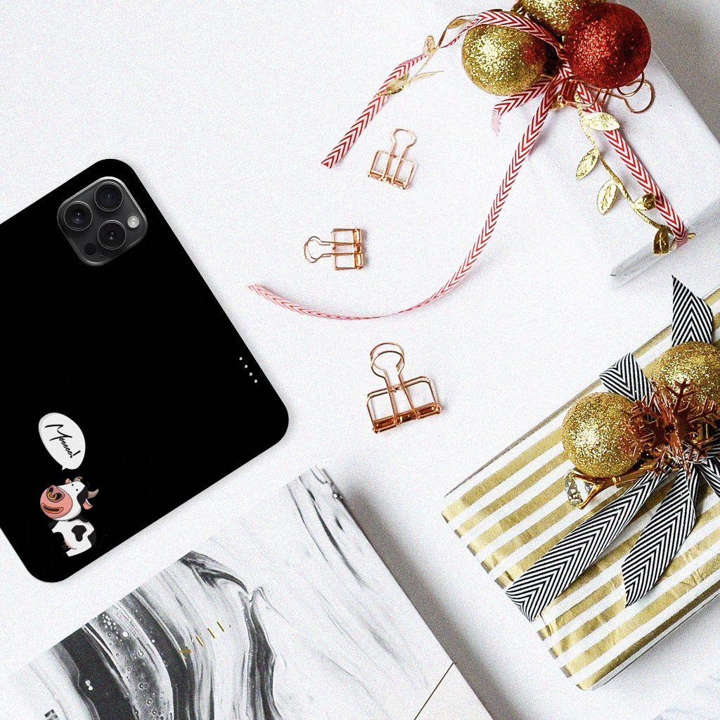 Detail van een iPhone 15 Pro Magnet Case Cow met cadeau's en decoraties op een witte tafel.