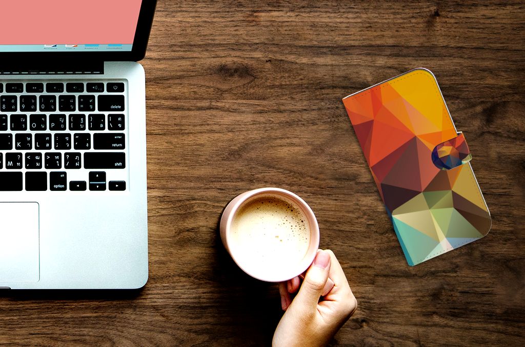 iPhone 15 Pro Max Book Case Polygon Color met kleurrijk geometrisch ontwerp op bureau met laptop en koffie.