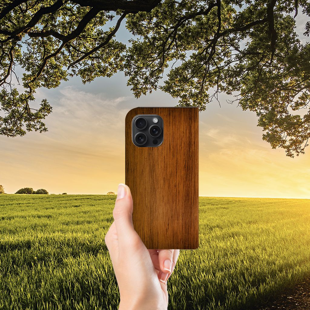 iPhone 15 Pro Max Book Wallet Case Donker Hout met natuurlijke achtergrond van een zonsondergang.