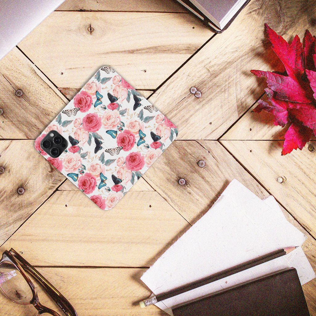 iPhone 15 Pro Max Smart Cover Butterfly Roses op een houten tafel met bladeren en notebook.