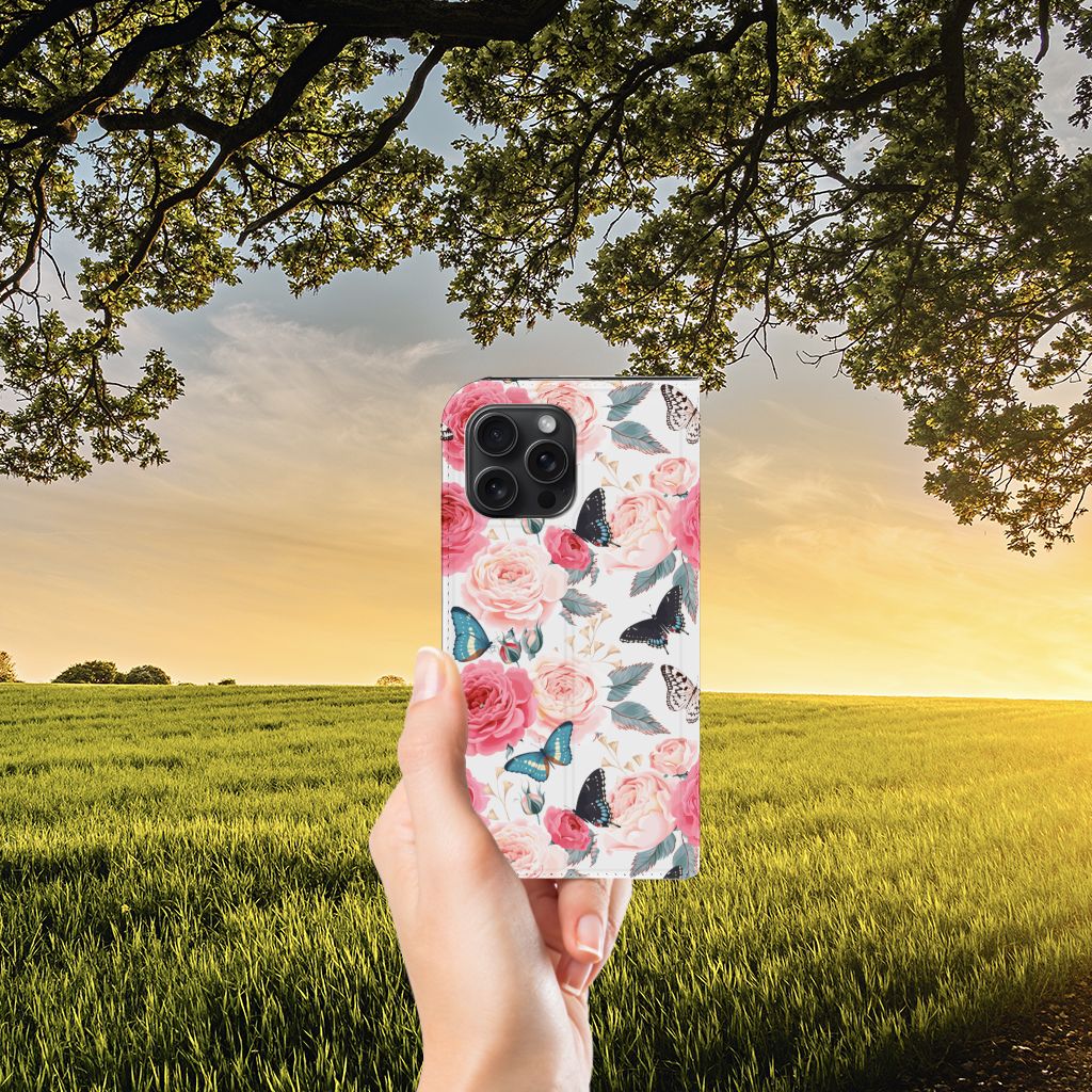 iPhone 15 Pro Max Smart Cover Butterfly Roses met rozen en vlinders in hand voor een zonsondergang.