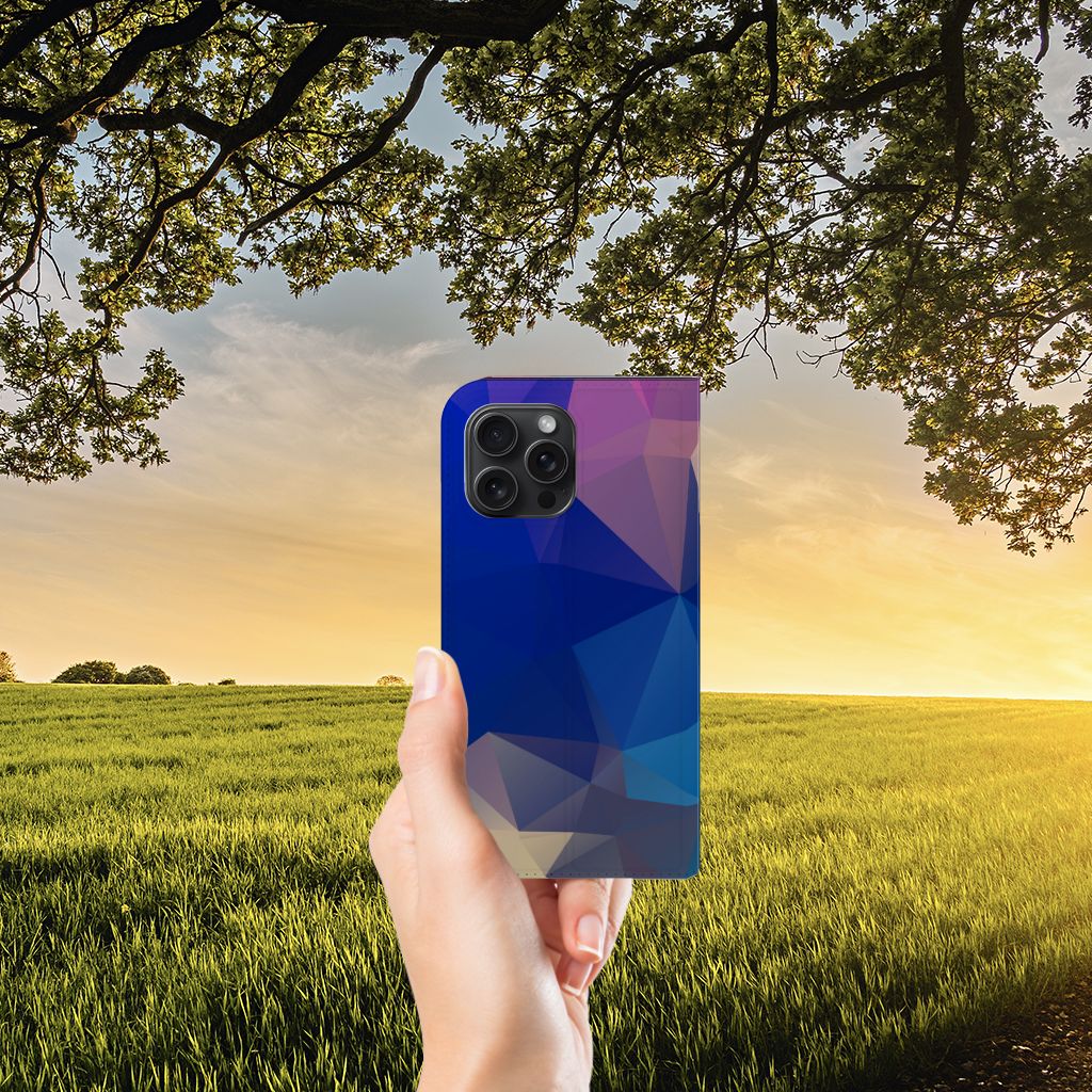 iPhone 15 Pro Max Stand Case Polygon Dark met abstract polygonen design in een hand te zien tegen een zonsondergang.