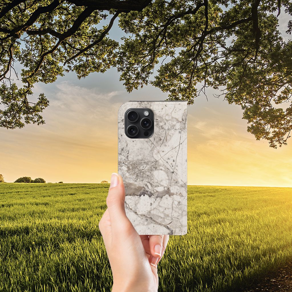 iPhone 15 Pro Max Standcase Marmer Beige bij zonsondergang 🌅 in hand gehouden.