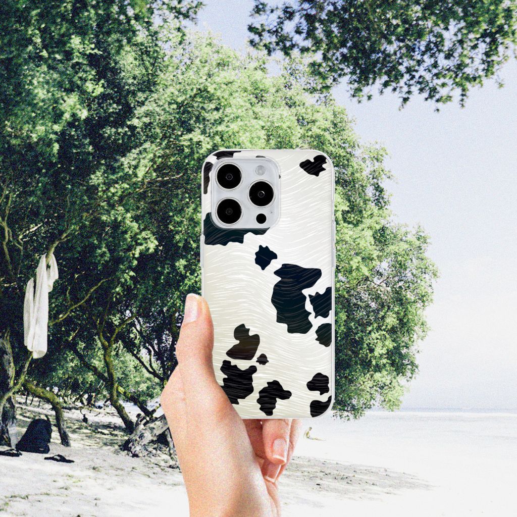 iPhone 15 Pro Max TPU Hoesje Koeienvlekken met zwart-witte koeienprint op een zonnige strandlocatie.