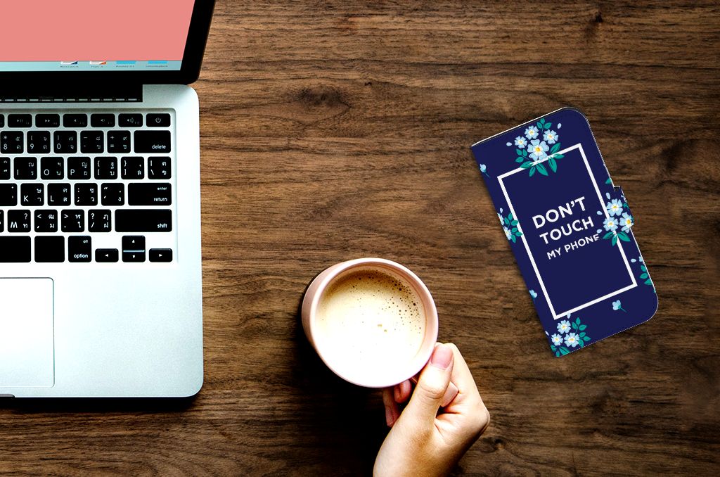 iPhone 15 Pro Portemonnee Hoesje Flowers Blue DTMP met de tekst 'DON'T TOUCH MY PHONE' op een bureau.