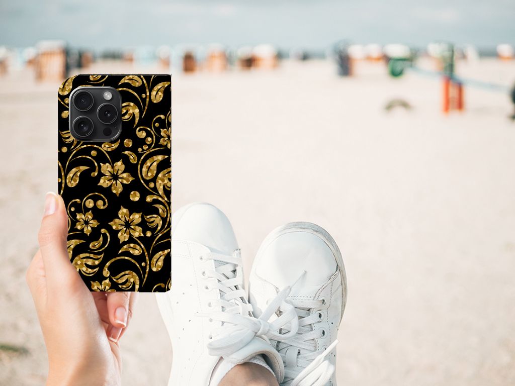 iPhone 15 Pro Smart Cover Gouden Bloemen in hand met sneakers op het strand