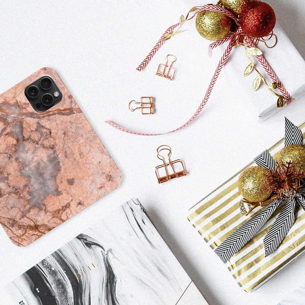 iPhone 15 Pro Standcase Marmer Oranje op een tafel met geschenken en decoraties.