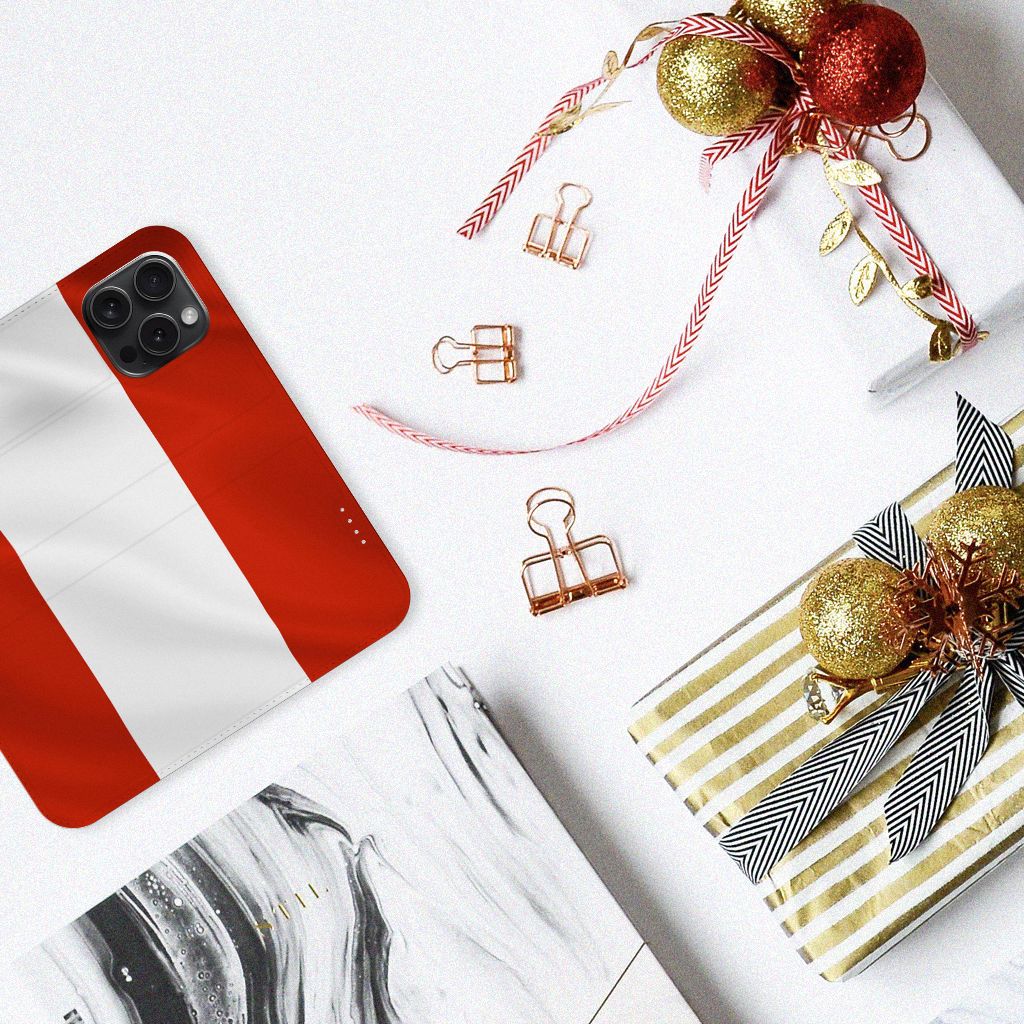 iPhone 15 Pro Standcase Oostenrijk met rode en witte strepen, naast kerstcadeaus en decoraties.