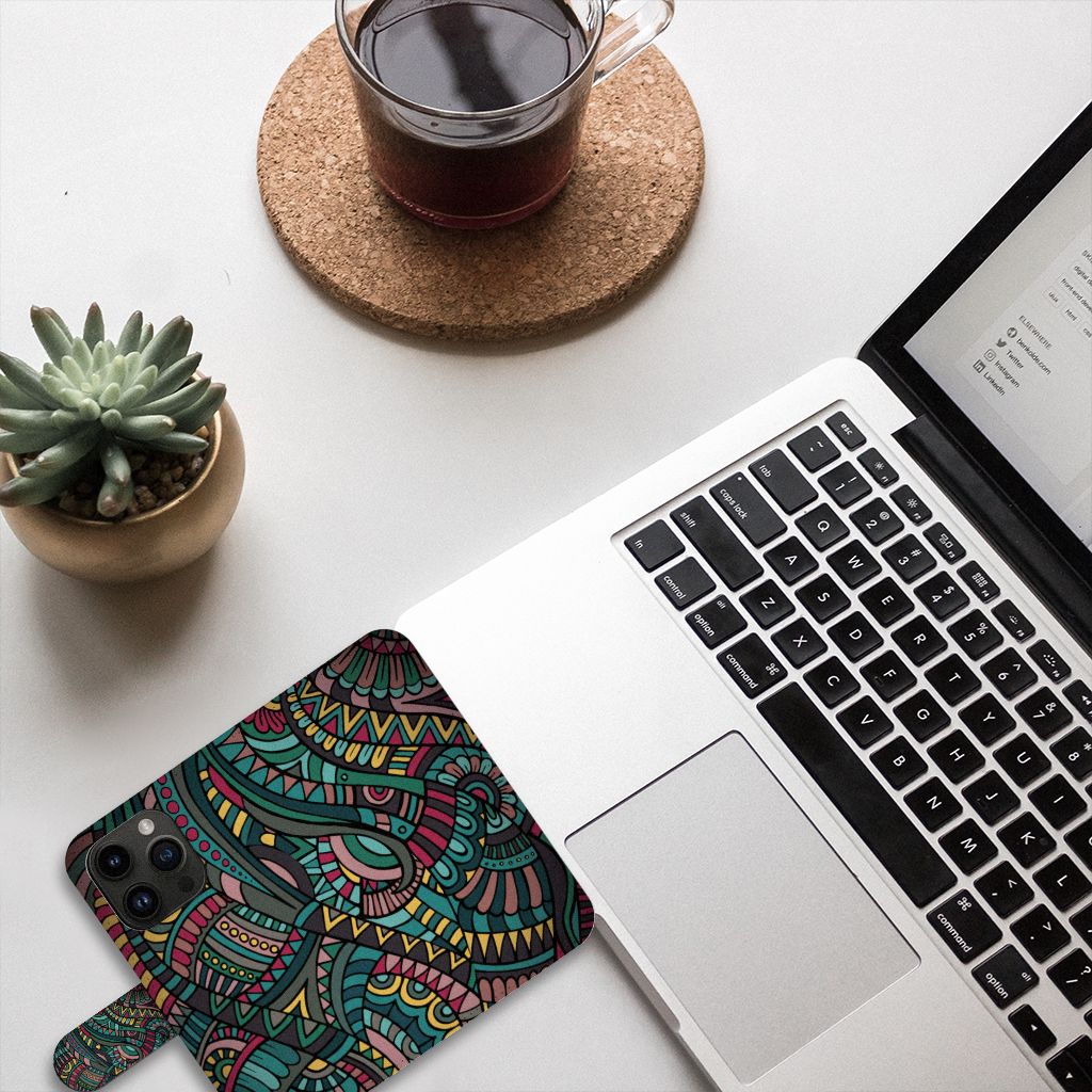iPhone 15 Pro Telefoon Hoesje Aztec met kleurrijk design op bureau naast laptop en plant 🌿.