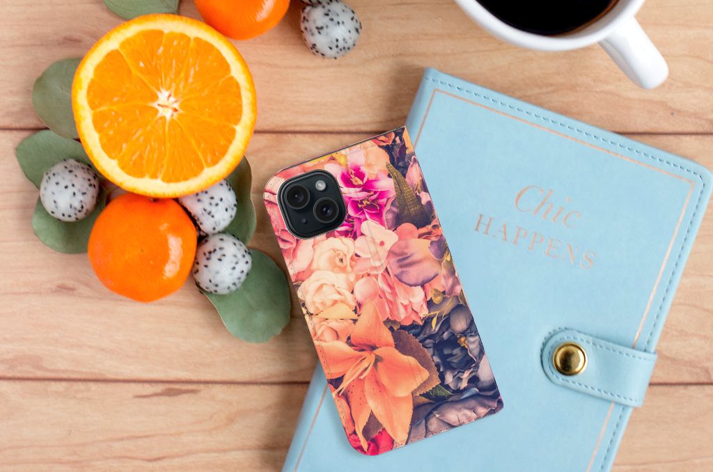 iPhone 15 Smart Cover Bosje Bloemen met kleurrijke bloemen, gelegen naast fruit en een notitieboekje.