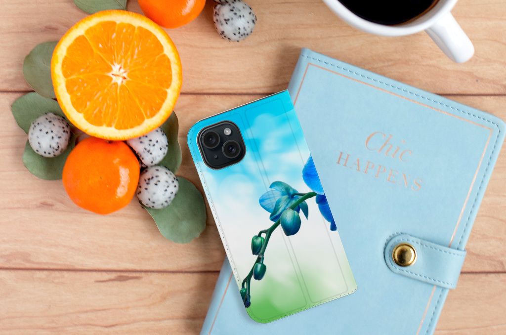 iPhone 15 Smart Cover Orchidee Blauw met prachtige orchidee op een tafel met fruit en notitieboek