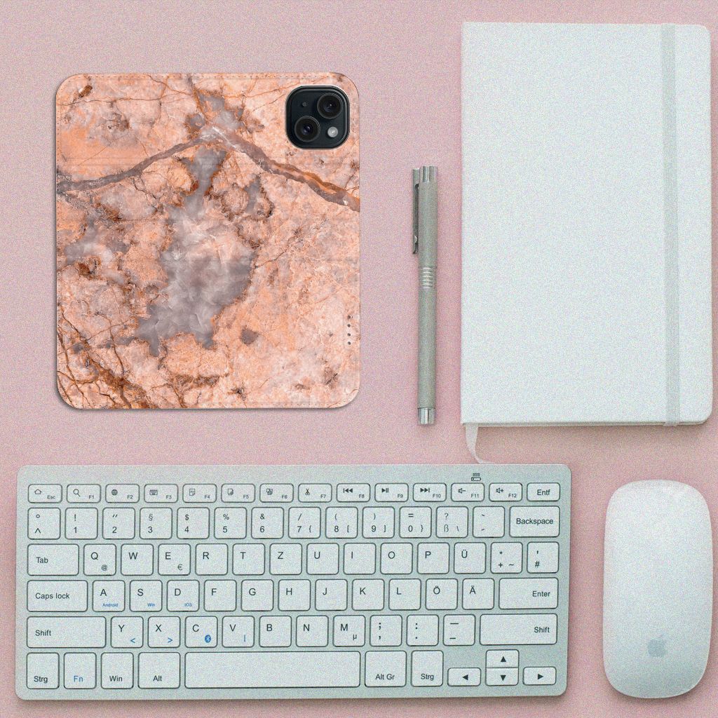 iPhone 15 Standcase Marmer Oranje op een bureau met toetsenbord en notitieboekje.