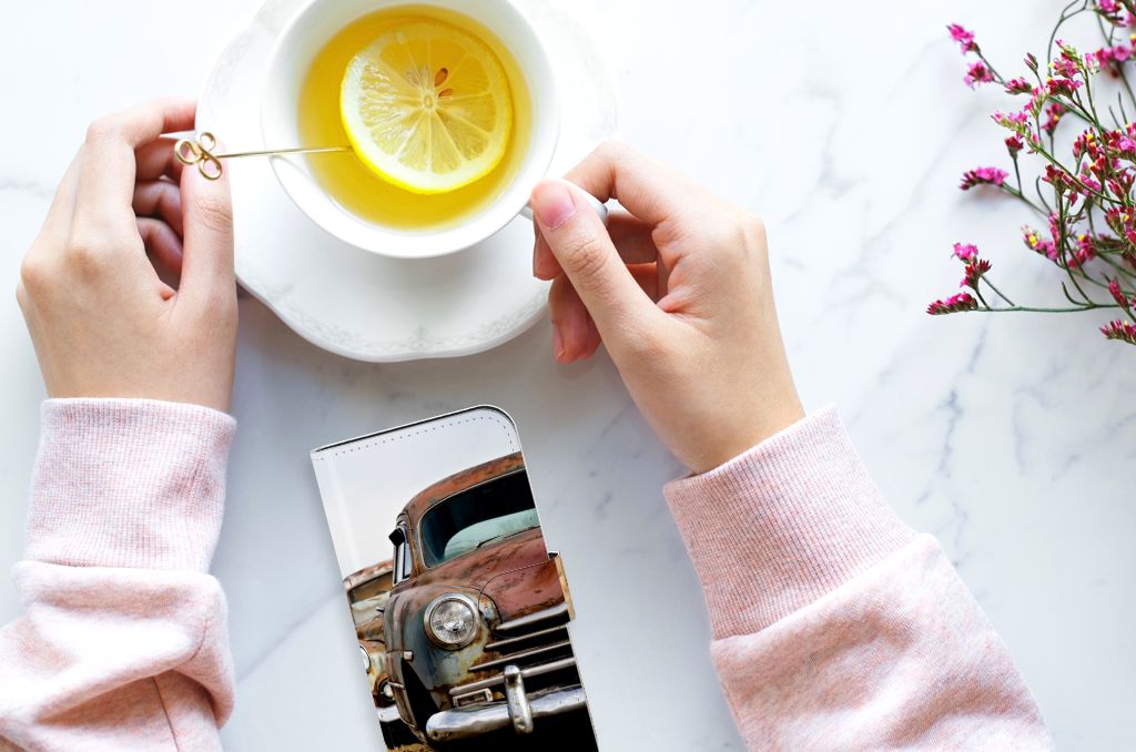 iPhone 15 Telefoonhoesje met foto Vintage Auto naast een kop thee met citroen en bloemen.