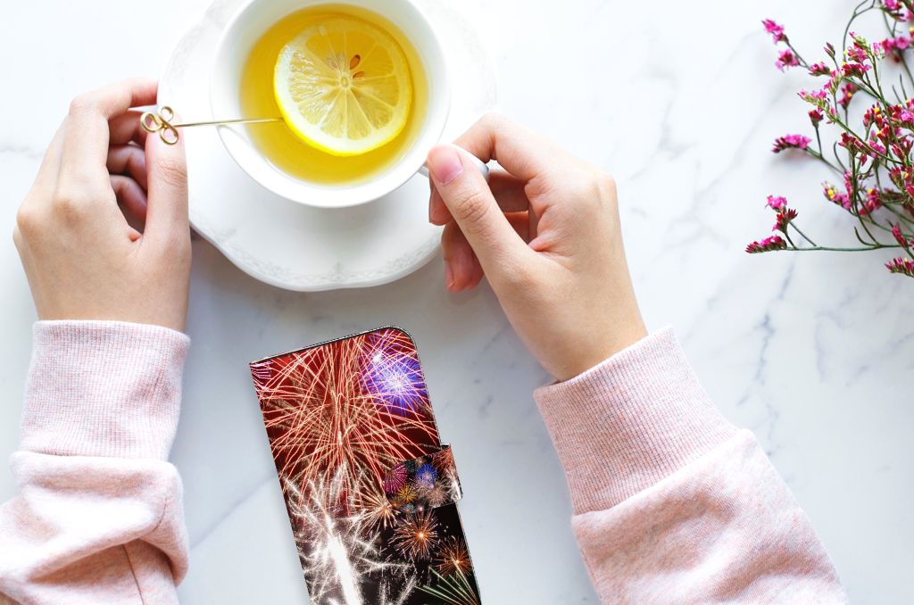 iPhone 15 Wallet Case met Pasjes Vuurwerk op een tafel naast een kopje warme citroen thee 🍵.
