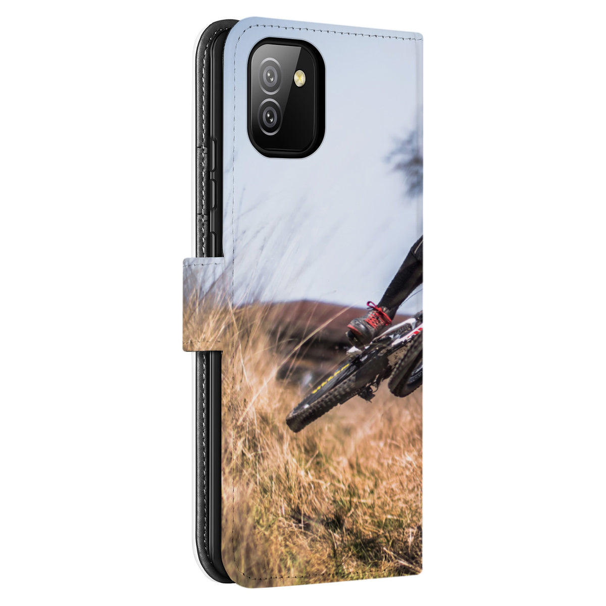 Schuin aanzicht van de achterkant van de Galaxy A03 bookcase met camera-uitsparing en een fietswiel in het gras