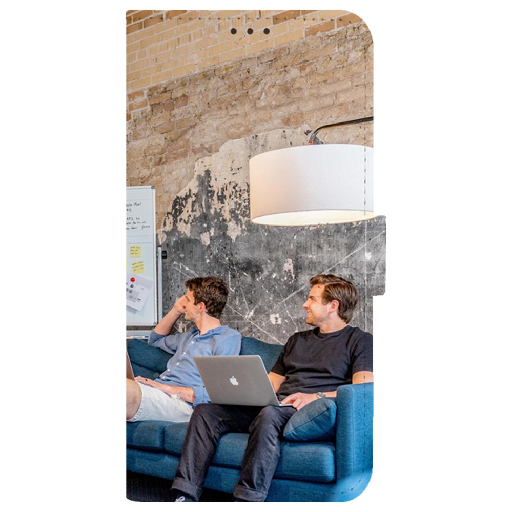 Voorkant Galaxy A20 bookcase: twee collega's met laptop op een blauwe bank onder een witte lamp